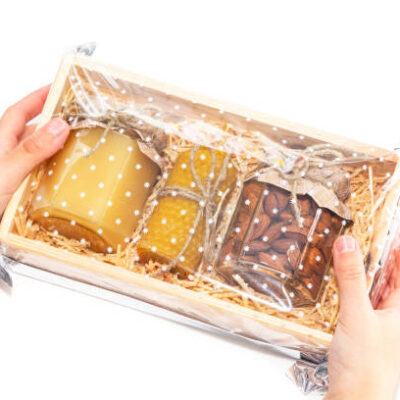 A jar of honey and different nuts in a wooden box, a gift