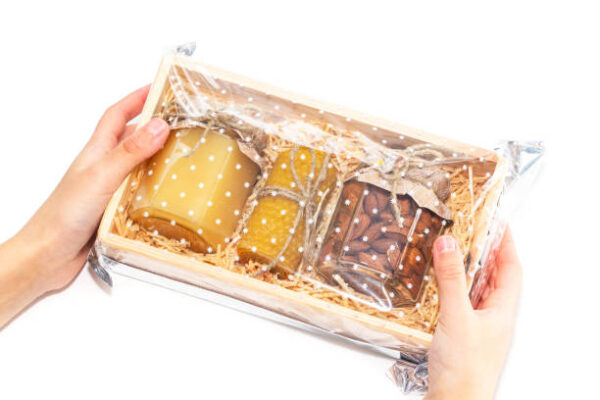 A jar of honey and different nuts in a wooden box, a gift