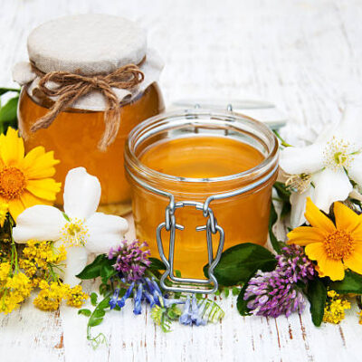 Honey and wild flowers on a wooden background