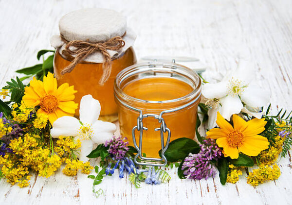Honey and wild flowers on a wooden background