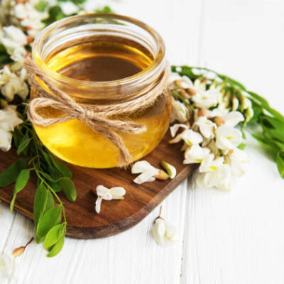 Honey with acacia blossoms on a wooden background